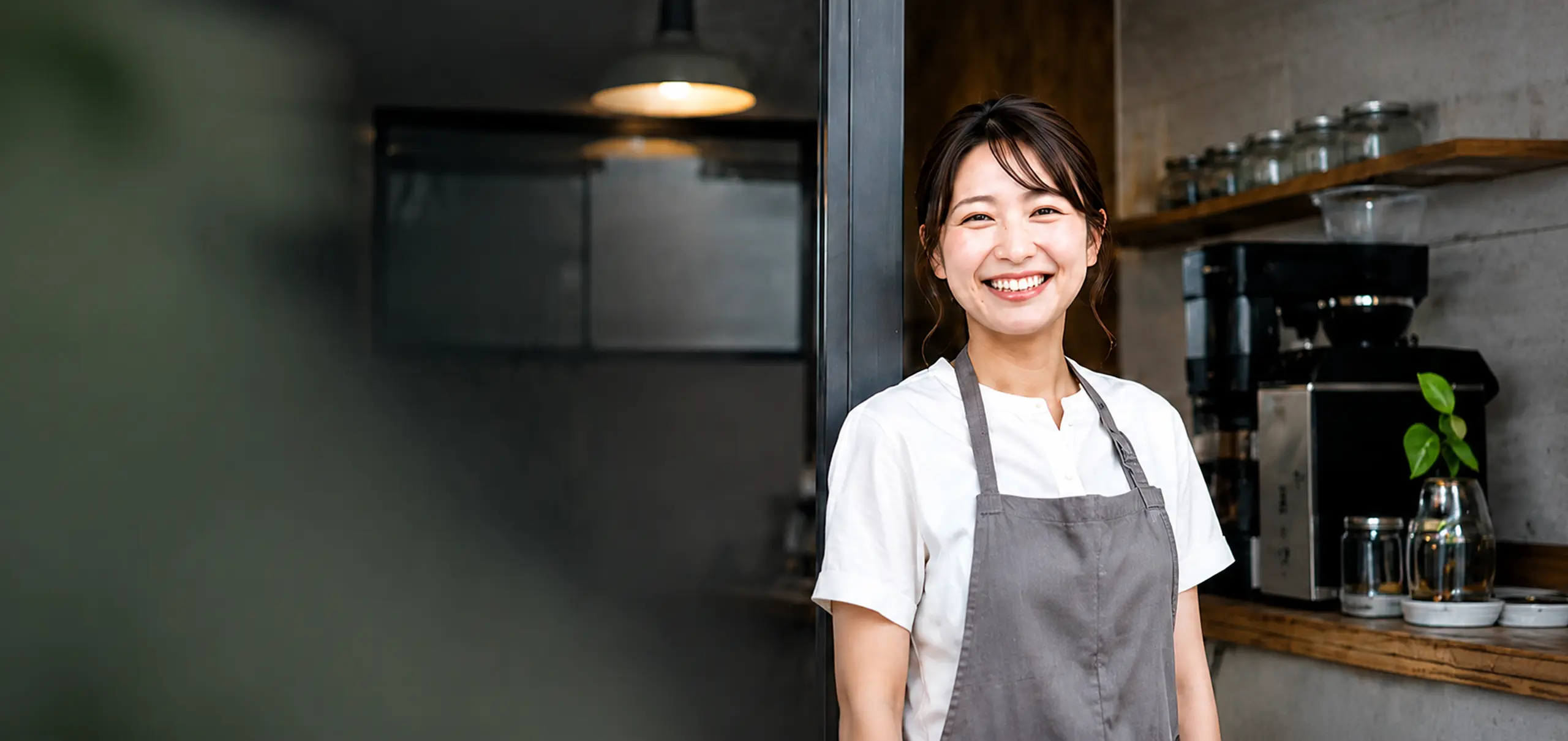 カフェで笑顔で立つ小さなお店のオーナー